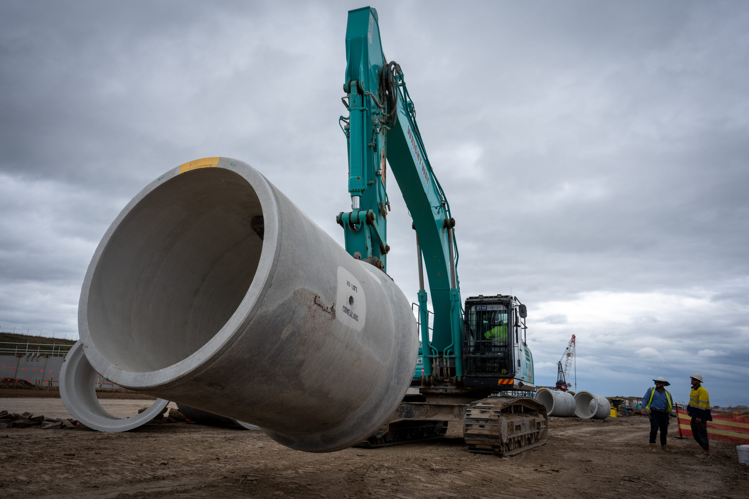 Excavator moving pipe with pipe lifter